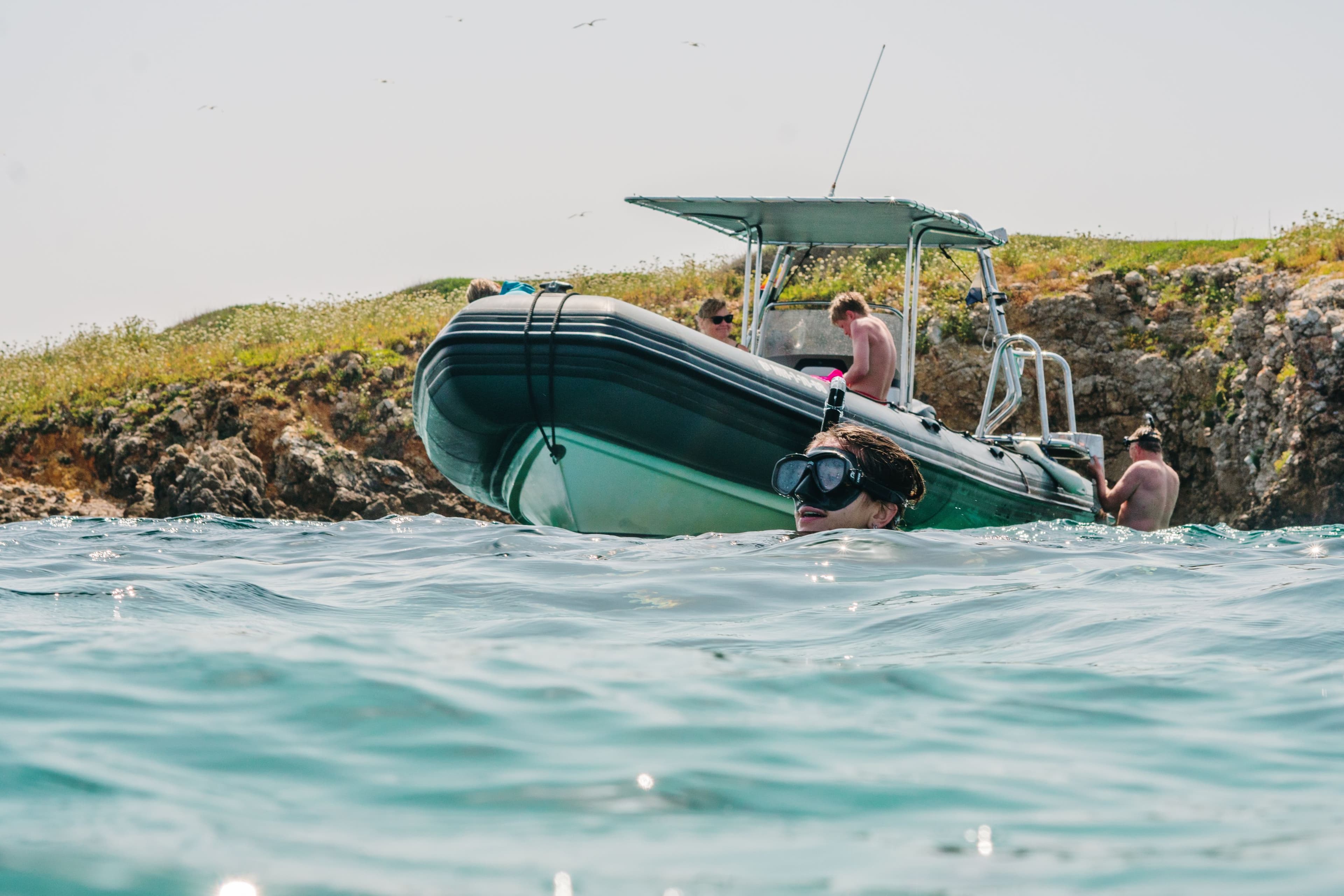 Speedboat navigating towards the entrance of a marine cave in the Menorca Marine Reserve.