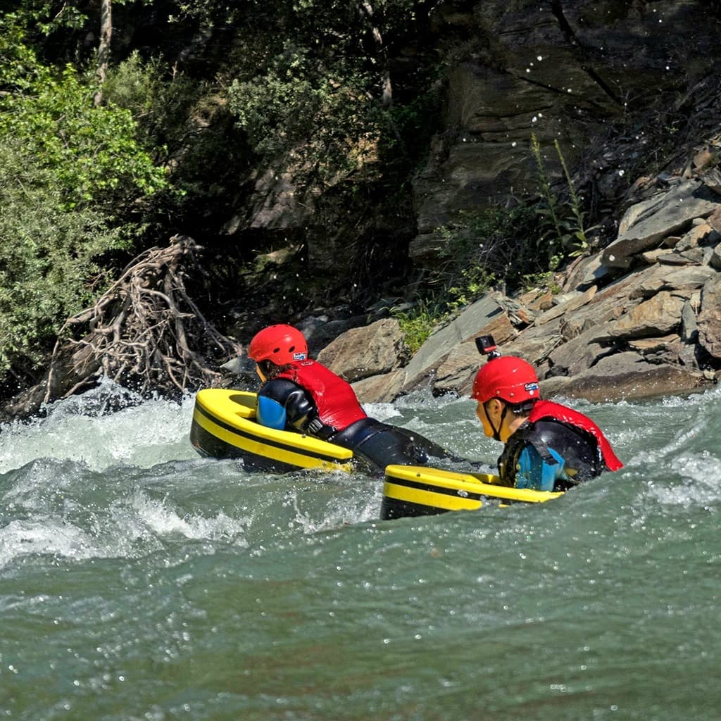 Person equipped with a helmet and reinforced suit navigating a rapid on the Noguera Pallaresa River on a hydrospeed board.