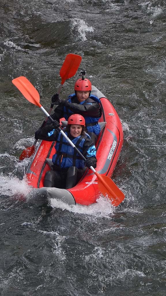 Kayakers navigating a white water stretch of the Noguera Pallaresa River in a self-bailing open kayak.